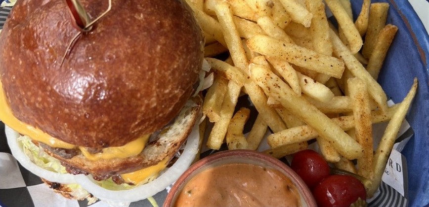 Photo of a cheeseburger with fries and a dip